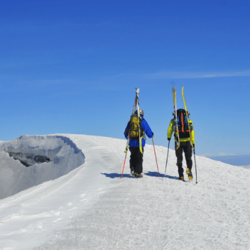 Esquiadores ascendiendo montaña nevada cerca de Pucón, actividad invernal